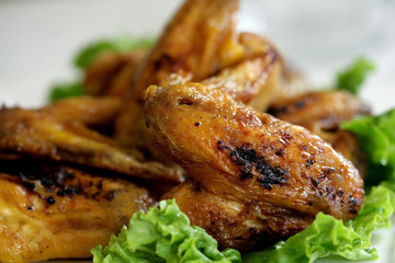 Close up of grilled chicken meat arranged with lettuce.