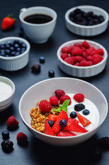 Healthy breakfast with granola, greek yogurt, berries and milk