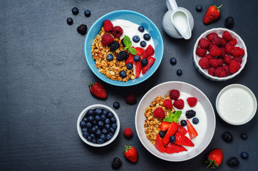 Healthy breakfast with granola, greek yogurt, berries and milk