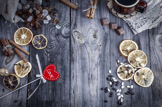 Red wooden heart on a gray surface with a coffee drink and sweets