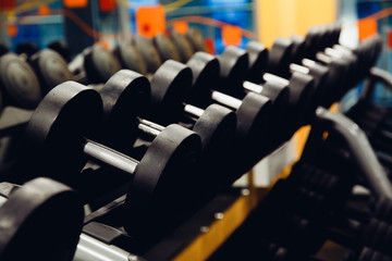 Fototapeta premium Sports equipment dumbbell rests in a row. high contrast and monochrome color tone.