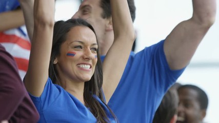  Excited fans with US flag in sports crowd cheering on their team