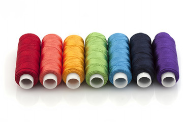Silk threads on reels, the colors of the rainbow on a white background. Isolated