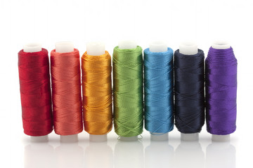 Silk threads on reels, the colors of the rainbow on a white background. Isolated