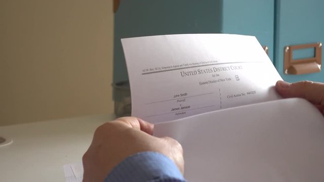 Hands open envelope after receiving subpoena letter