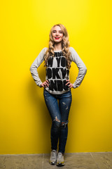 portrait of the beautiful young woman on the yellow background