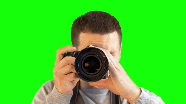 Greenscreen Photographer Facing Straight Holding Up DSLR Camera and Snapping Photo