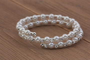 Silver bracelet on a wooden background. Party decorations.