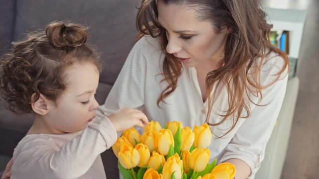 Mother and daughter holding yellow tulips