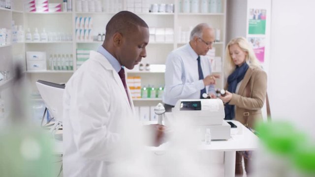  Team of staff working & serving customers in a chemist shop