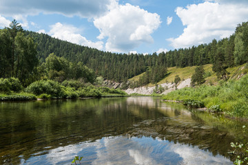 Mirror-like surface of river Belaya among mountains in summer day