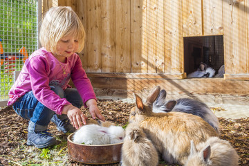 Mädchen im Stall mit Hasen