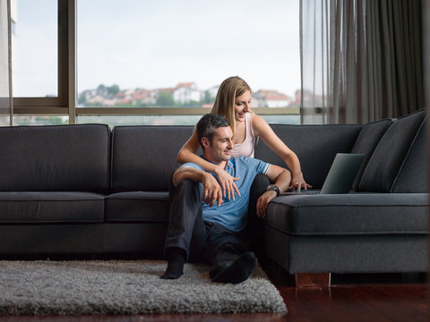 Attractive Couple Using A Laptop on couch