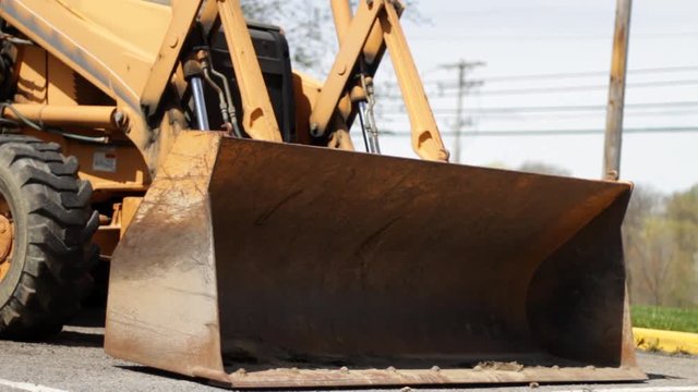 Excavator machine front bucket sitting in parking lot