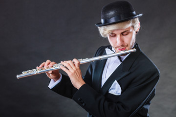 Elegantly dressed male musician playing flute © anetlanda