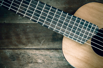 Part of guitar on wooden background