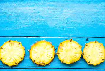 the summer pineapple is slice for eat on blue wooden background. copy space for designer