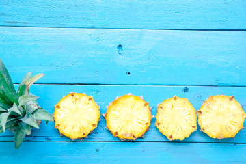 the summer pineapple is slice for eat on blue wooden background. copy space for designer