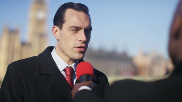  Businessman or politician giving live interview to reporter in London