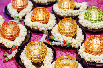 Colorful burning candles and ritual flowers in a Buddhist temple