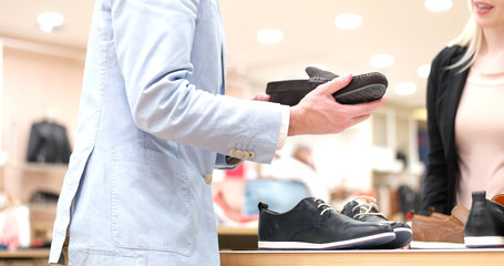 Man Chooses Shoes At Shoe Store