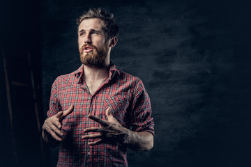 A positive bearded male dressed in a red fleece shirt tells a story with hand movement.