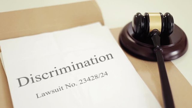Discrimination lawsuit verdict folder with gavel placed on desk of judge in court