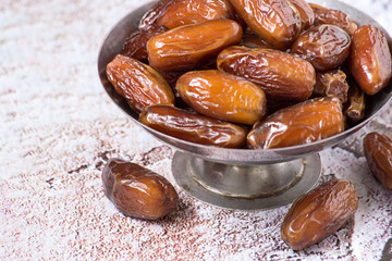 
 Healthy food. Dry sweet dates in a round metal vase.
