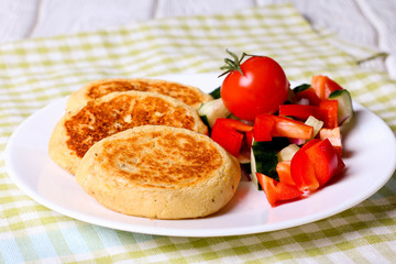 Roasted vegetable cutlets on a plate. Healthy cutlets cooked of potatoes, green peas, carrots and green beans. Vegetarian lunch or dinner recipe. Fresh vegetables on wooden table