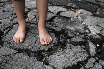 Foot on the crack asphalt road.