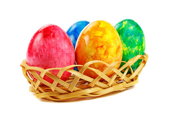 Colored Easter eggs in basket on white background