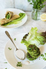 pila di falafel verdi di piselli, salsa tahini, erbe aromatiche e tortilla di farina di ceci farcite