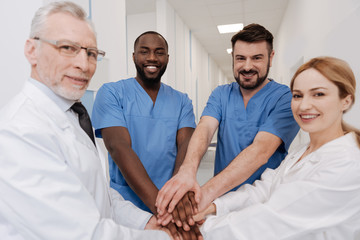 Obraz premium Positive medics practicing teambuilding in the hospital