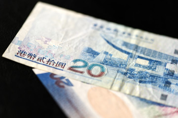 Two bills of twenty Hong Kong dollars on a dark background