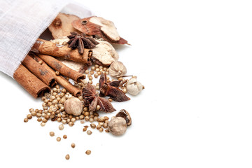 Chinese spices blend : cinnamons, star anises, galanga, best cardarmom and coriander seeds in white bag on white background isolated with copy space
