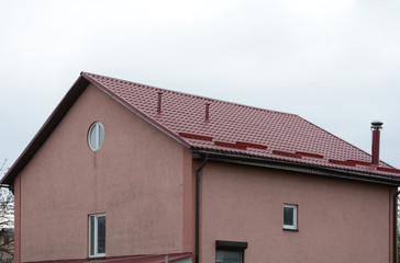 Metal roofing construction. Rain gutter and snow guard. Chimney coaxial. House with individual heating.