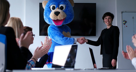 boss dresed as bear having fun with business people in trendy office