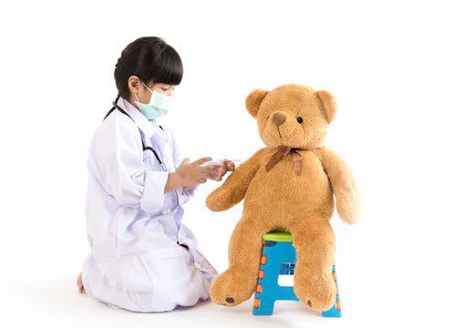 Asian Child Playing Doctor With Injection To Teddy Bear