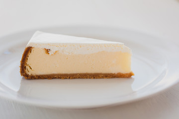 Piece of cheesecake on a white plate close-up