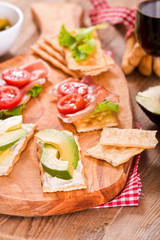 Crackers with ham and avocado. 