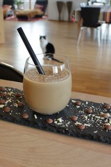 Icecold glass of chocolade milkshake on tray decorated with chocolade and white chocolade flakes