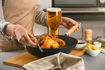 Woman with grilled beer can chicken in pan on table