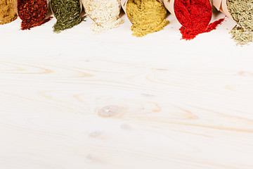 Varied powder spices close-up on  white wooden board with  copy space.