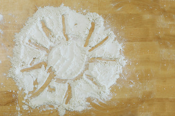 Amorous cook drew with his finger sign of the sun on the flour