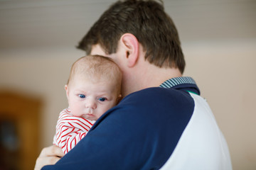 Happy proud young father with newborn baby daughter, family portrait togehter