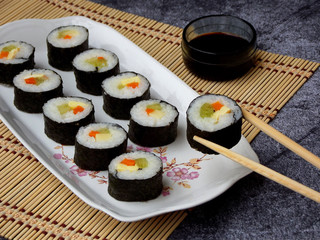 Sushi on white plate, grey background. Traditional Asian food. Diet healthy food. Selective focus. Space for text