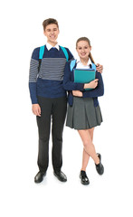 Cheerfully smiling boy and girl in elegant school uniform standing on light background