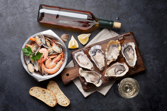 Fresh seafood and white wine on stone table