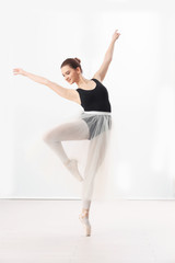 Ballet art concept. Young beautiful ballerina training in dance hall