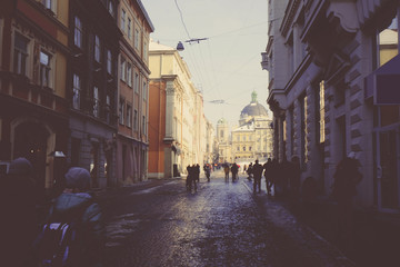 City street with old buildings and lot of people in winter